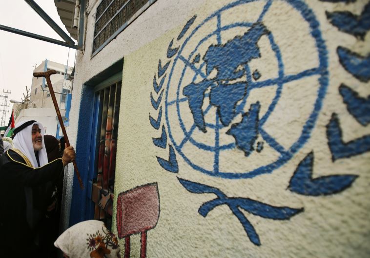A Palestinian refugee knocks on the closed gate of the United Nations Relief and Works Agency (UNRWA) headquarters with his walking stick A Palestinian refugee knocks on the closed gate of the United Nations Relief and Works Agency (UNRWA) headquarters with his walking stick
