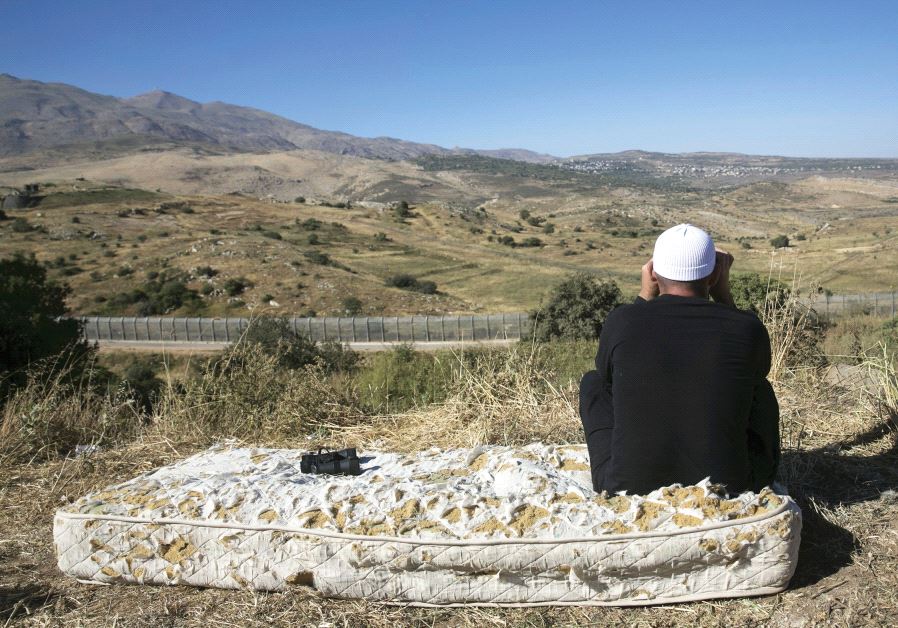 A DRUSE man watches the fighting in Syria from the Israeli side of the Golan Heights A DRUSE man watches the fighting in Syria from the Israeli side of the Golan Heights