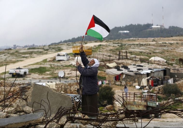 A Palestinian man hangs a Palestinian flag atop the ruins of a mosque, during a snow storm in West Bank village of Mufagara A Palestinian man hangs a Palestinian flag atop the ruins of a mosque, during a snow storm in West Bank village of Mufagara